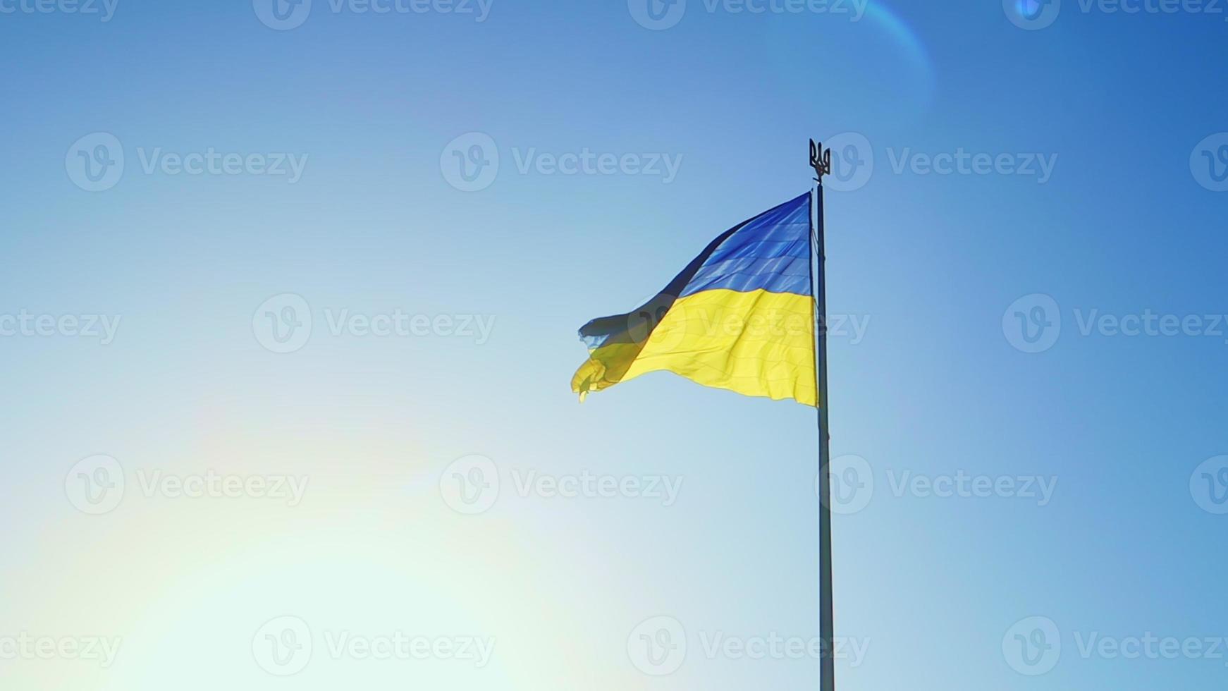 drapeau au ralenti de l'ukraine agitant au vent contre un ciel sans nuages à l'aube du jour. Le symbole national ukrainien du pays est bleu et jaune. boucle de drapeau avec texture de tissu détaillée. photo