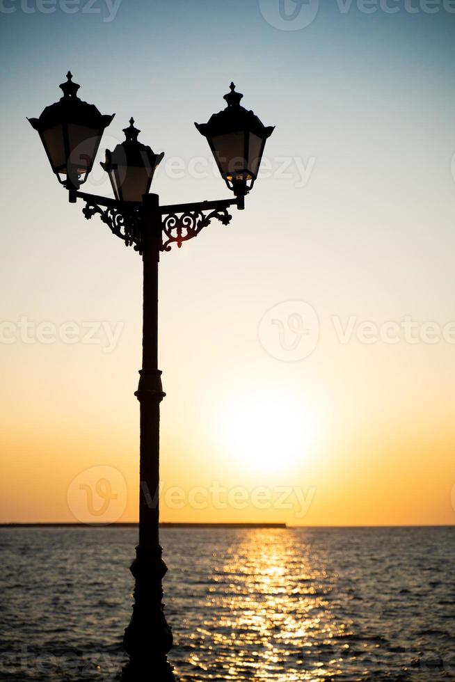 lanterne sur la côte de la mer au coucher du soleil photo