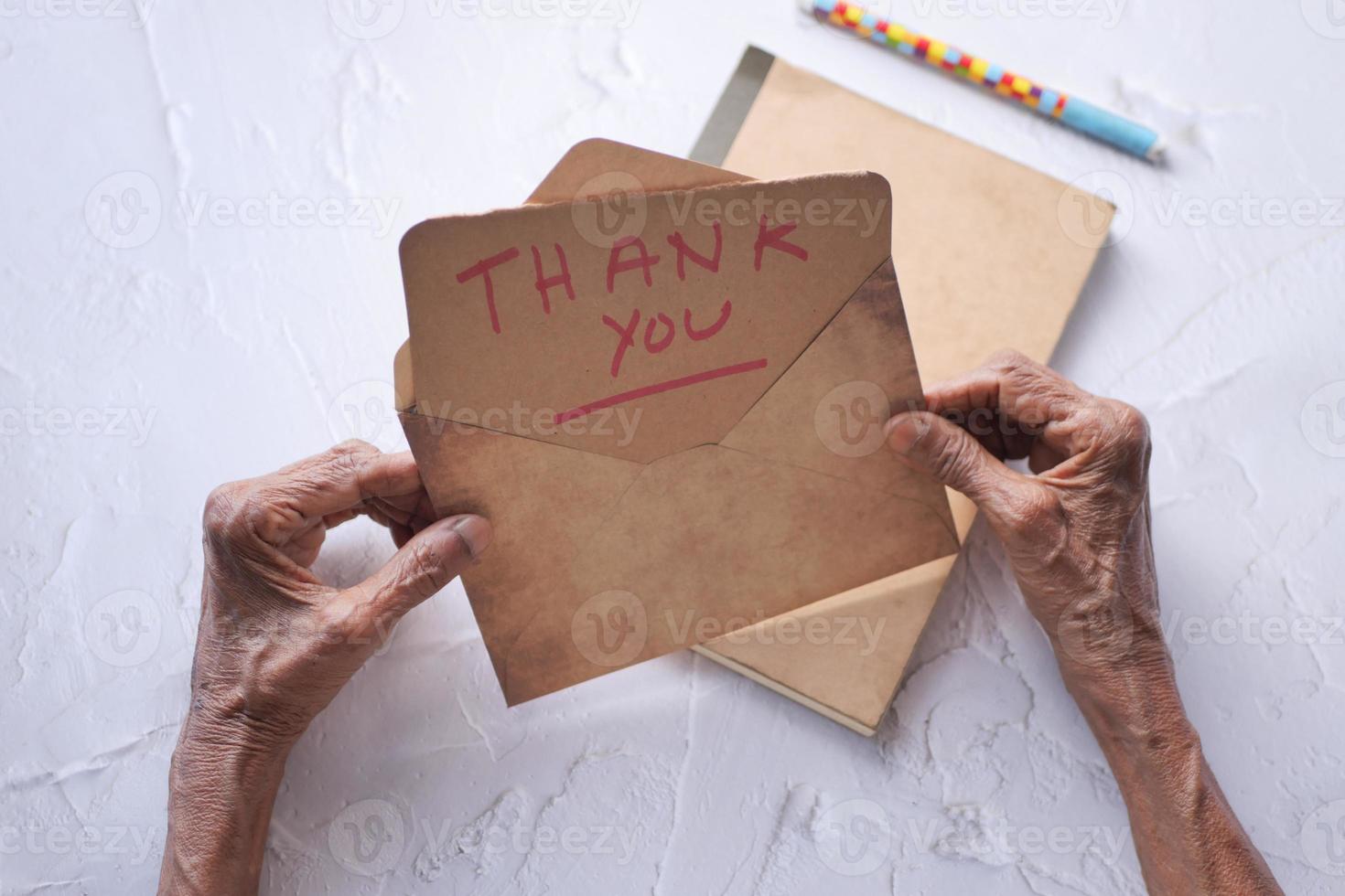 main de femme âgée tenant une lettre de remerciement, vue arrière photo