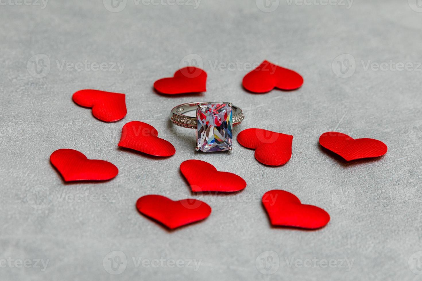 veux-tu m'épouser. bague de mariage de nombreux coeurs rouges sur fond gris pierre béton. concept de mariage de proposition de mariage de fiançailles. St. carte postale de la saint valentin. bannière le jour de la saint valentin. photo