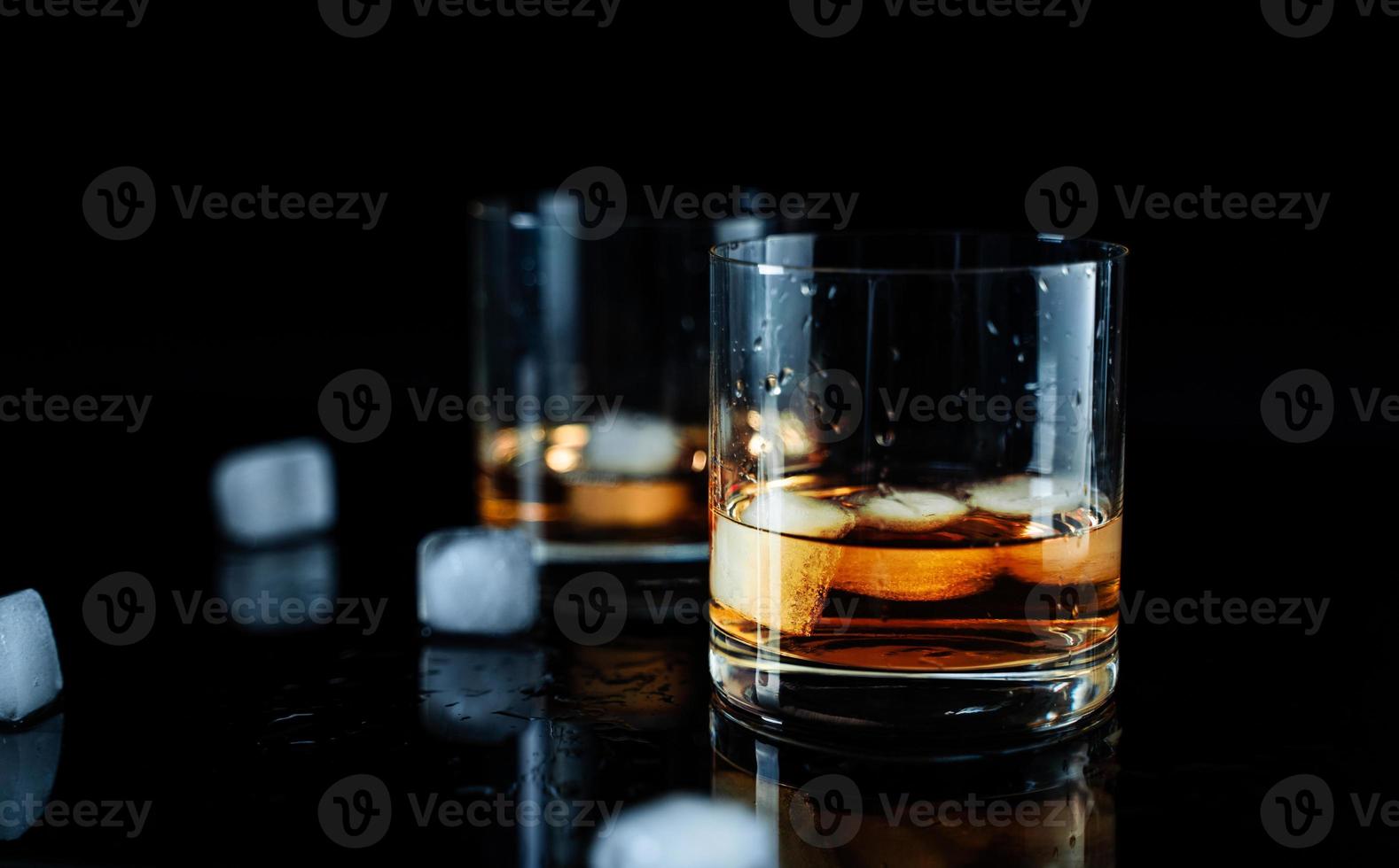 élégant verre simple de whisky de luxe sur fond noir. arrière-plan isolé en verre de whisky brillant, prise de vue en studio. espace de copie. boisson alcoolisée forte. photo