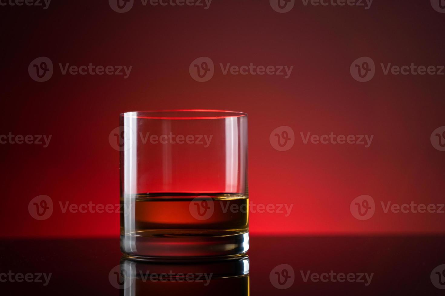 élégant verre simple de whisky de luxe sur fond noir. arrière-plan isolé en verre de whisky brillant, prise de vue en studio. espace de copie. boisson alcoolisée forte. photo