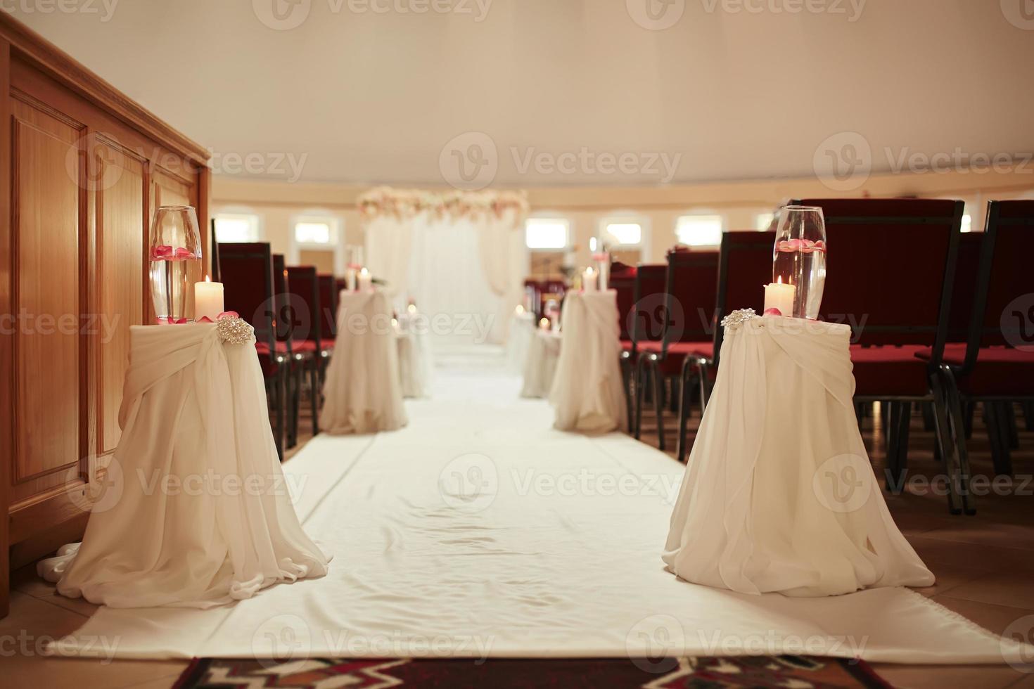 décoration de mariage une bougie et un vase avec de l'eau sur un tableau blanc. les vases avec de l'eau et des bougies se tiennent sur la table de mariage photo
