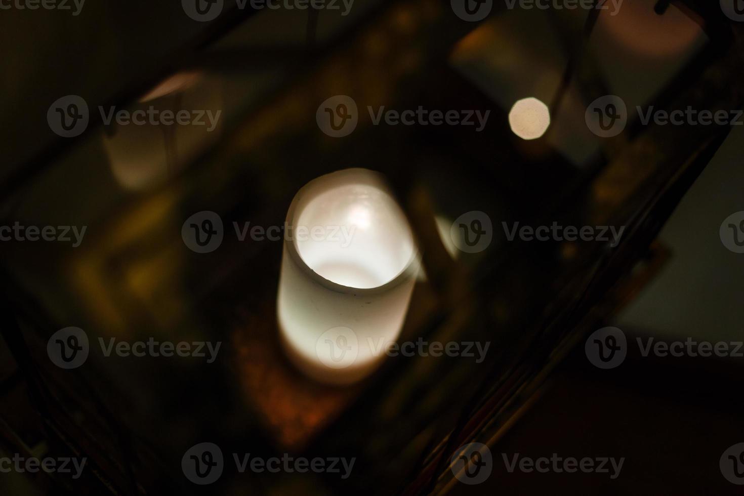 lanterne de noël avec des bougies de neige vue depuis la fenêtre sur le fond de la rue de nuit photo