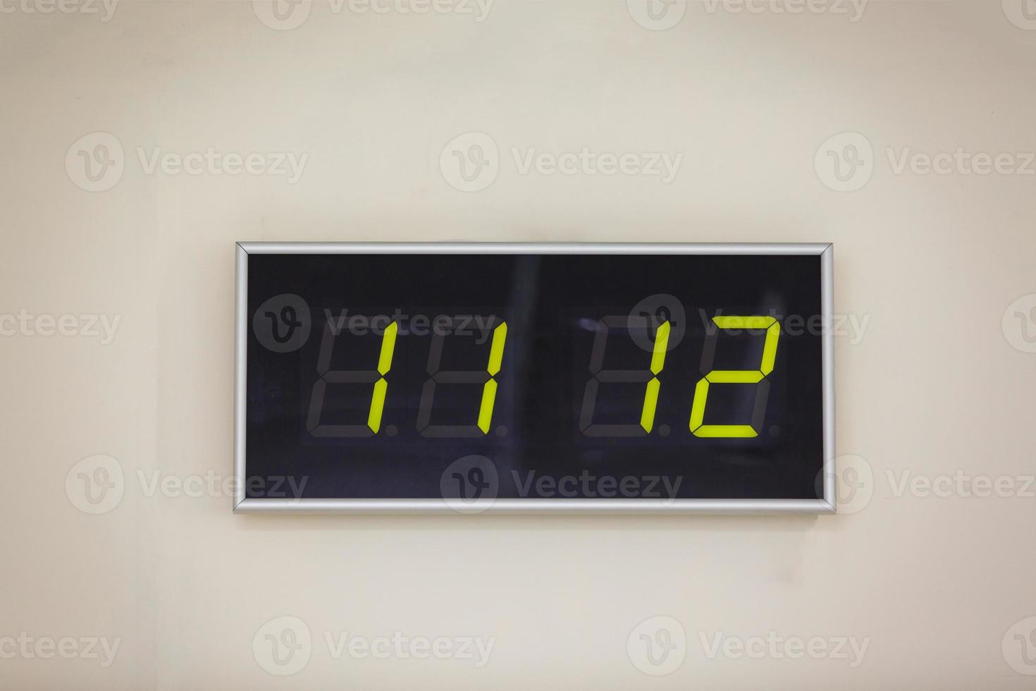 Horloge numérique noire sur fond blanc indiquant l'heure onze heures douze minutes photo