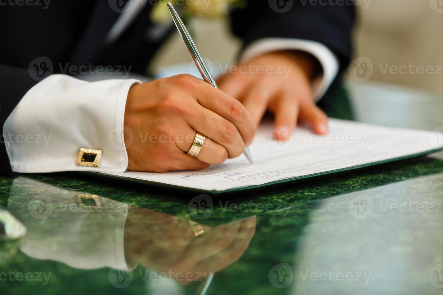 la main de l'homme avec le stylo écrit sur une feuille de papier propre photo