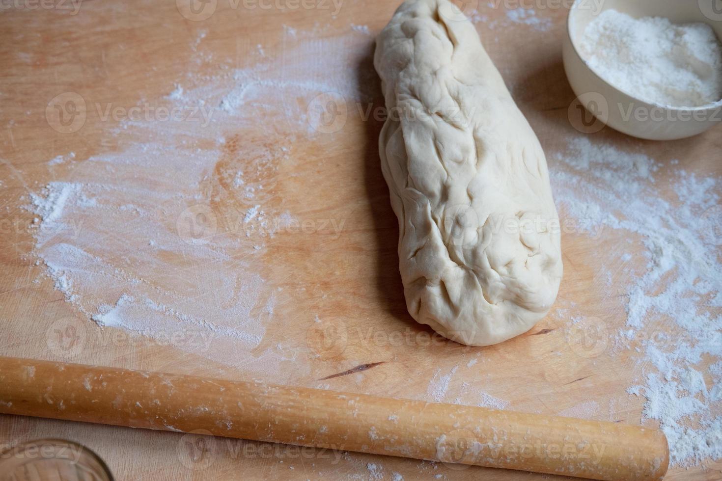 travailler sur un test de rouleau à pâtisserie inachevé. préparer des pâtisseries à partir de pâte photo