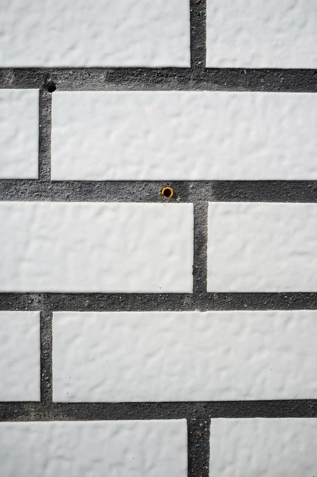 fond texturé. mur de la maison est soigneusement garni de tuiles qui ressemblent à des briques blanches. espace de copie. photo