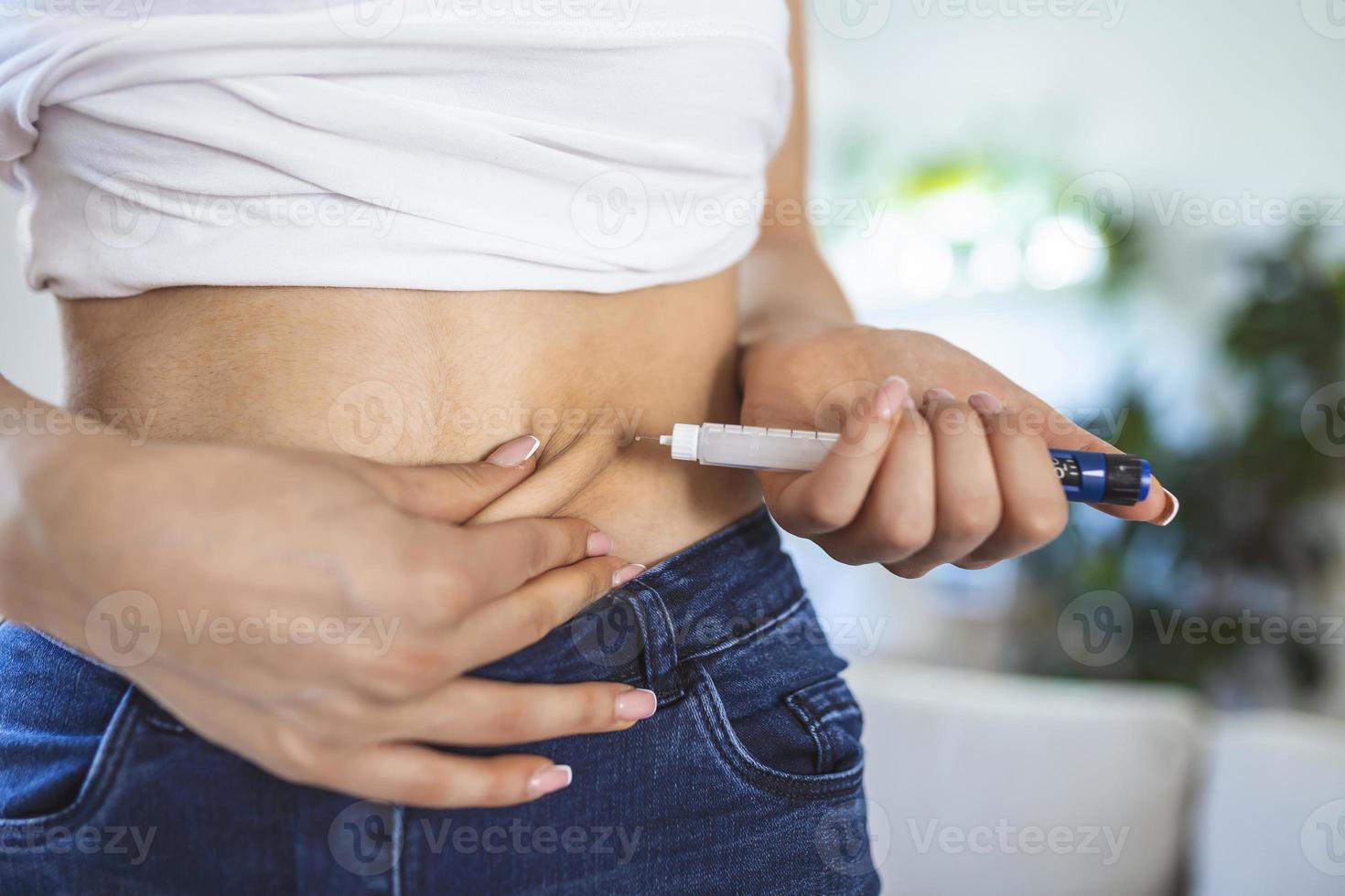 un patient diabétique utilisant un stylo à insuline pour faire une injection d'insuline à la maison. jeune femme contrôle le diabète. mode de vie diabétique photo