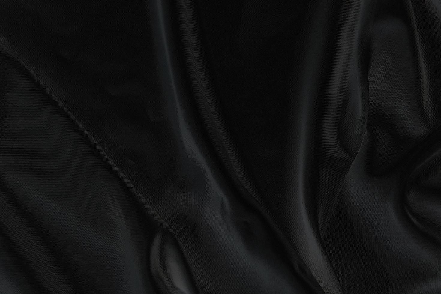 tissu de soie noir élégant lisse ou texture de tissu de luxe satiné pour fond abstrait photo