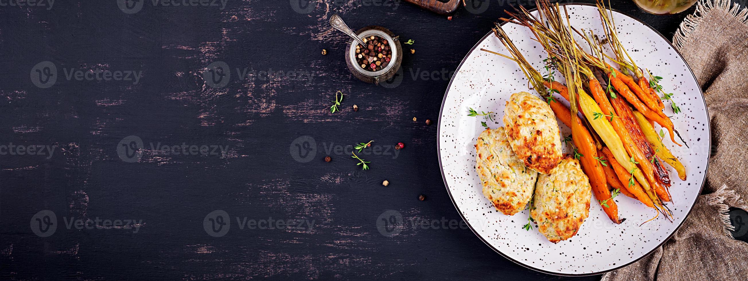 carottes biologiques cuites au four avec thym et escalope, viande de poulet aux boulettes de viande et courgettes. nourriture diététique. bannière. vue de dessus photo