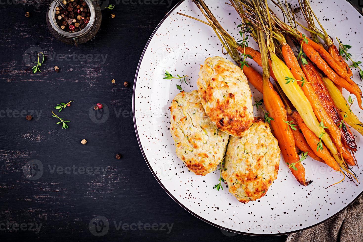 carottes biologiques cuites au four avec thym et escalope, viande de poulet aux boulettes de viande et courgettes. nourriture diététique. vue de dessus photo