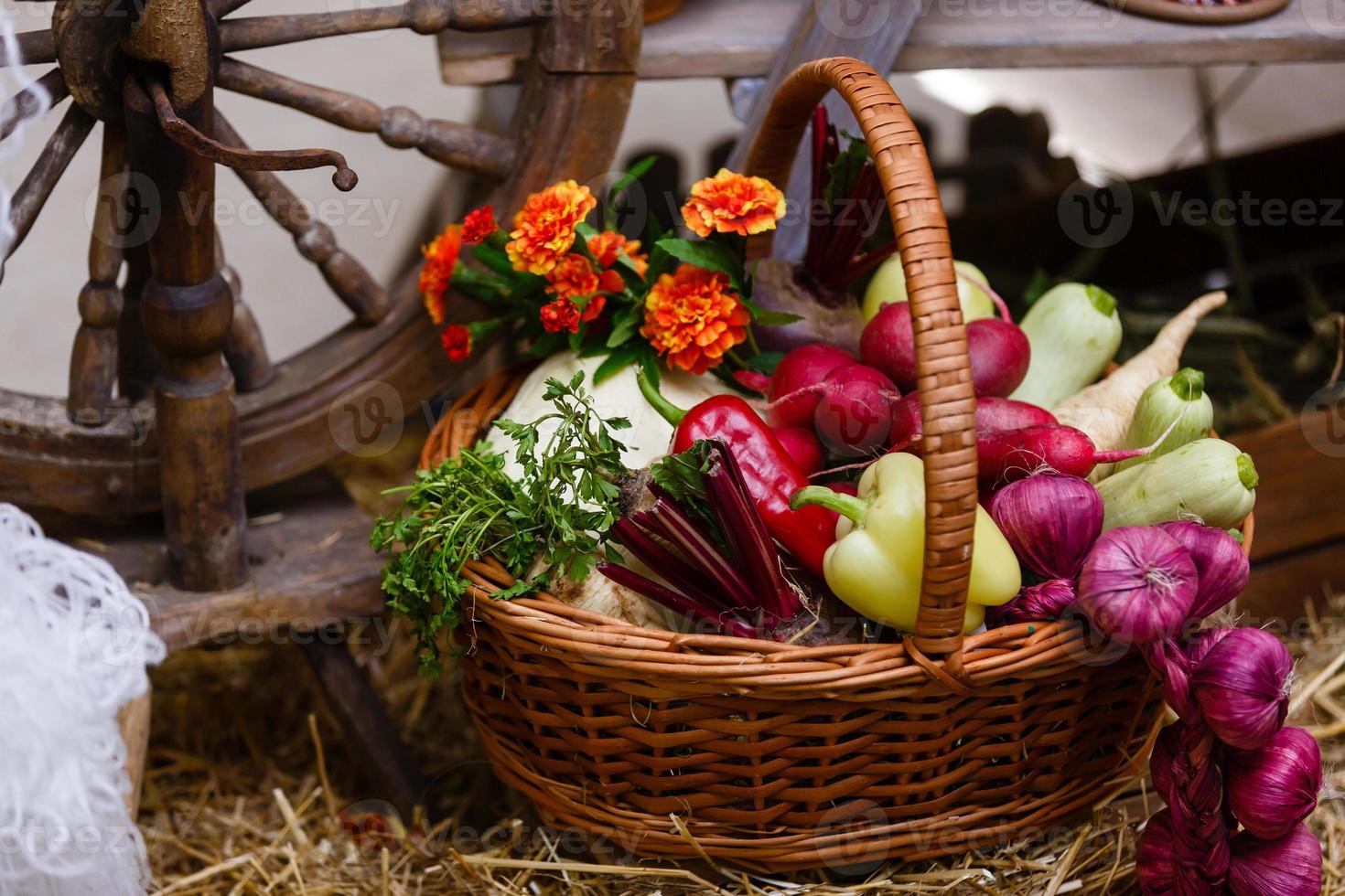 panier avec des légumes biologiques sur l'herbe verte et les fleurs. en plein air. légumes fraîchement récoltés. légumes crus dans un panier en osier.panier de légumes et de fleurs photo