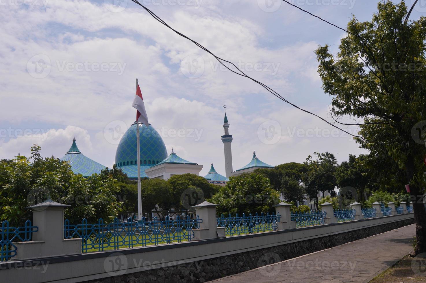 paysage d'un dôme de mosquée à surabaya avec des arbres et des drapeaux flottant sur des poteaux photo