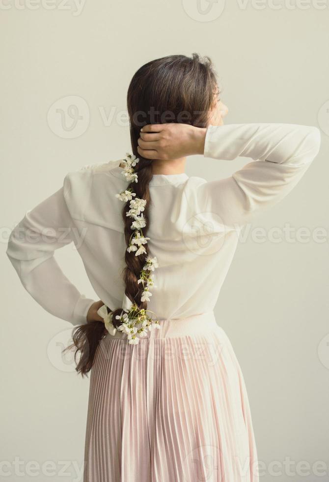 Close up young woman holding tresse avec des fleurs blanches concept photo