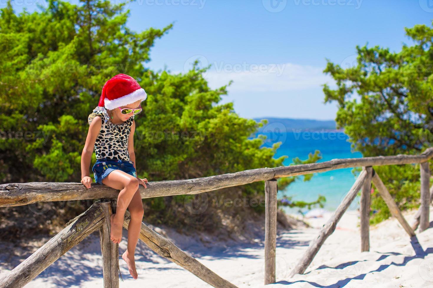 adorable petite fille au chapeau de noël pendant les vacances d'été à la plage photo