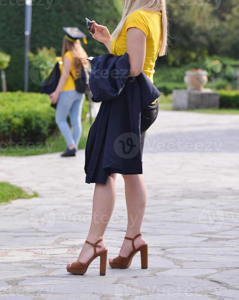 les étudiants diplômés de l'université font une séance photo dans le parc