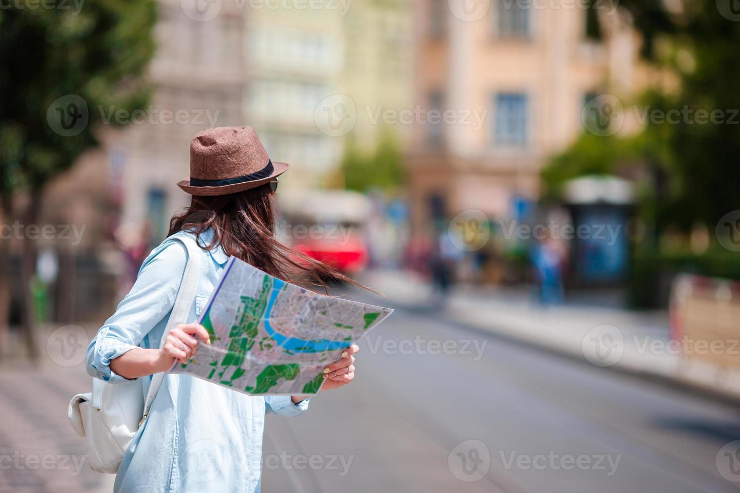 jeune femme regardant la carte touristique de la ville. une fille heureuse profite de vacances en europe. photo