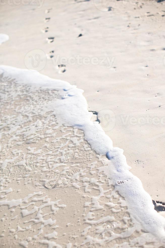 empreintes humaines sur la plage de sable blanc photo