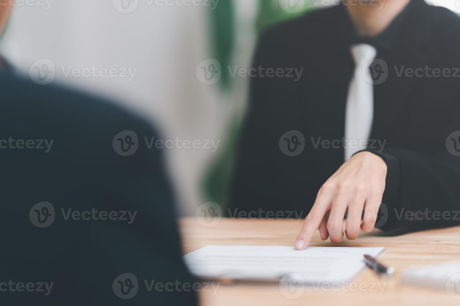 homme d'affaires pointant sur le document et remettant le stylo au client, gestion des documents commerciaux et des accords, signature des contrats commerciaux, approbation des documents contractuels ou des certificats de garantie. photo