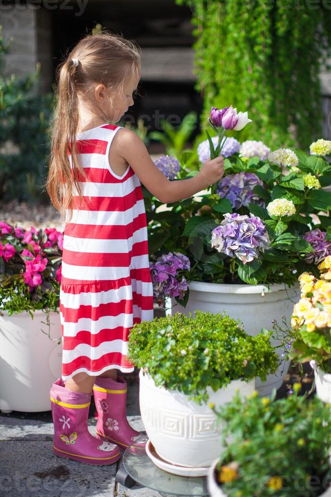 douce petite fille tenant un bouquet de tulipes dans la cour photo