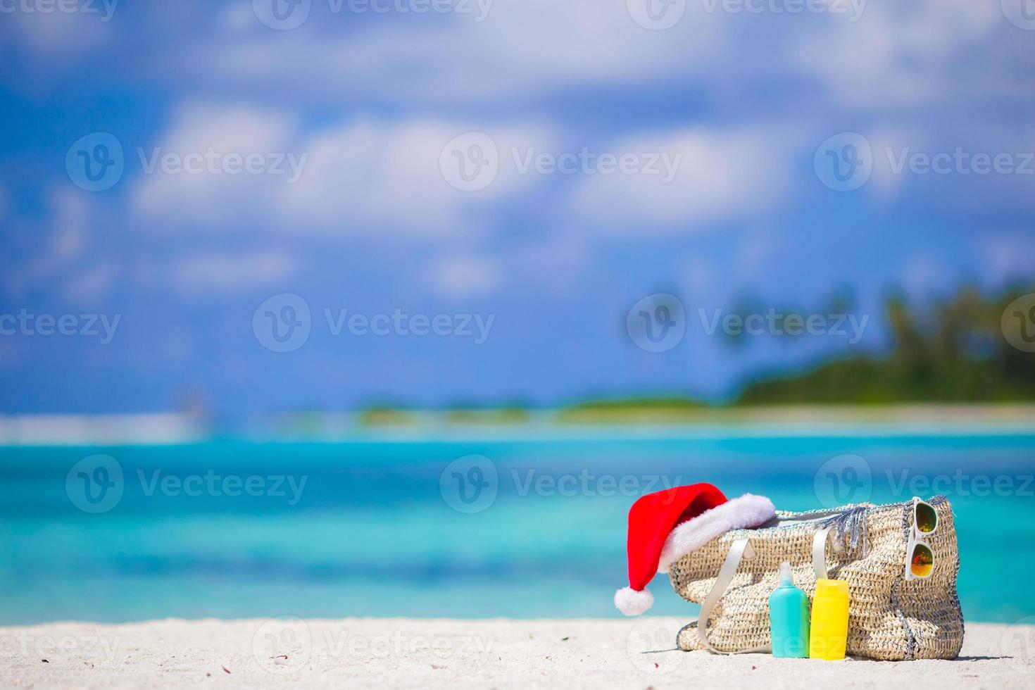 accessoires de plage avec bonnet de noel sur une plage tropicale blanche photo