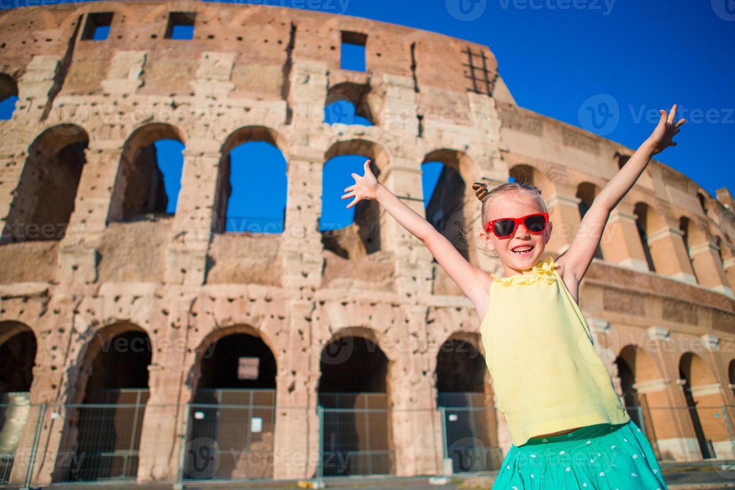 adorable petite fille active s'amusant devant le colisée à rome, italie. enfant passant son enfance en europe photo