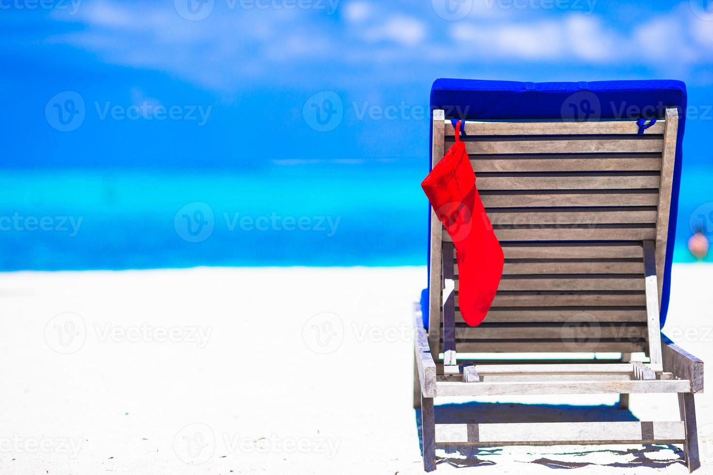 bas de noël rouge sur une chaise au fond d'un café en plein air la mer photo