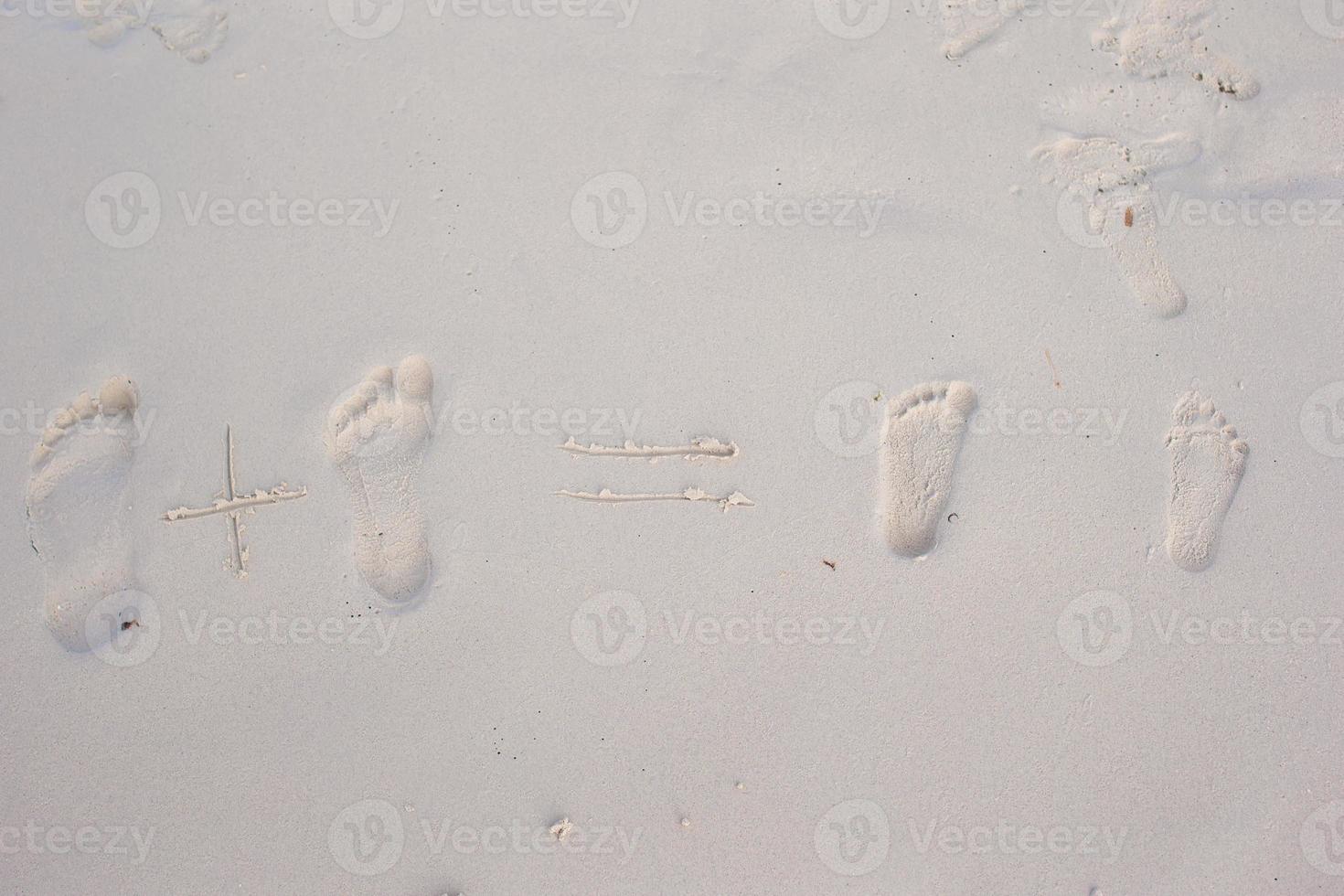 empreintes de famille sur la plage de sable blanc photo