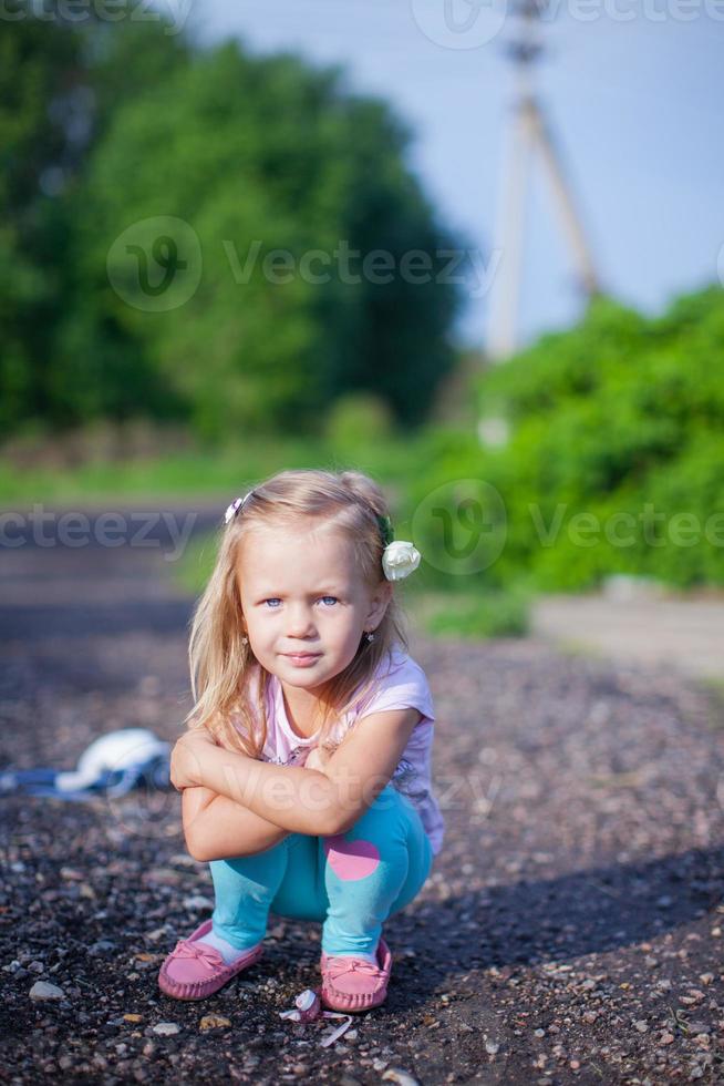 jolie fille assise sur leurs hanches en plein air et riant photo