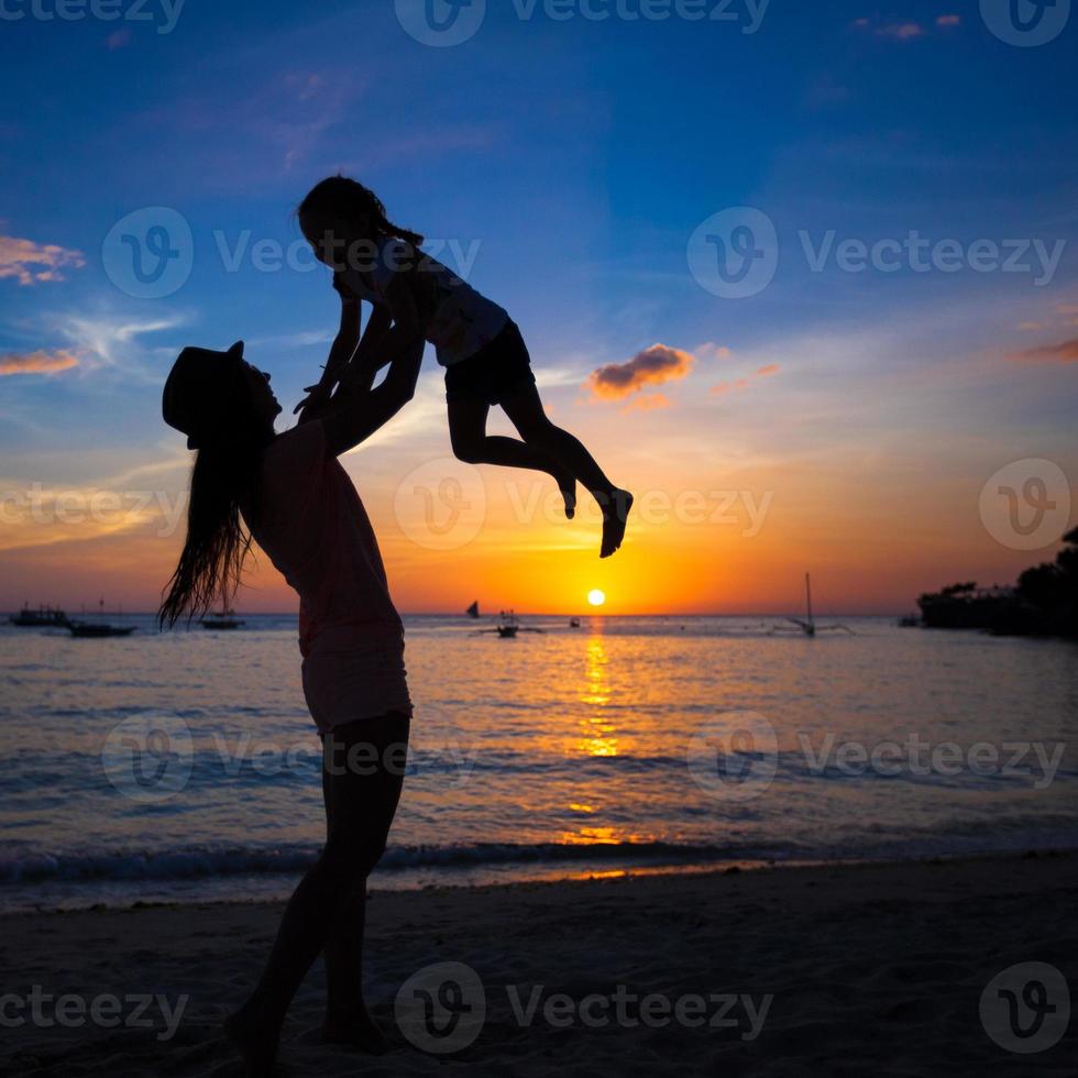 silhouette de mère et petite fille jouant sur la plage boracay, philippines photo