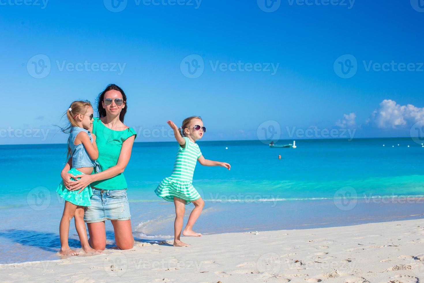 petites filles mignonnes et jeune mère pendant les vacances à la plage tropicale photo