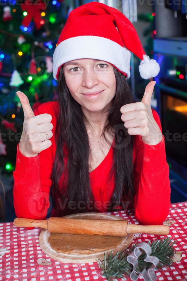 jeune femme au chapeau de noël levé le pouce levé à la maison photo