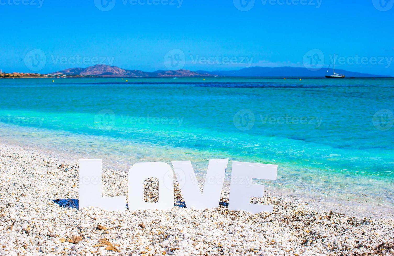 mot amour sur fond de plage tropicale de mer turquoise et ciel bleu photo