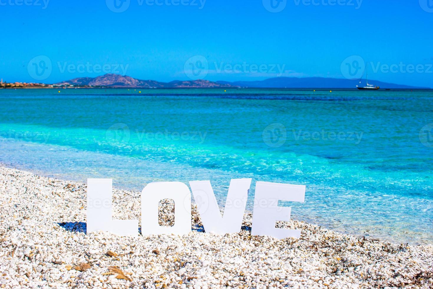 mot amour sur fond de plage tropicale de mer turquoise et ciel bleu photo