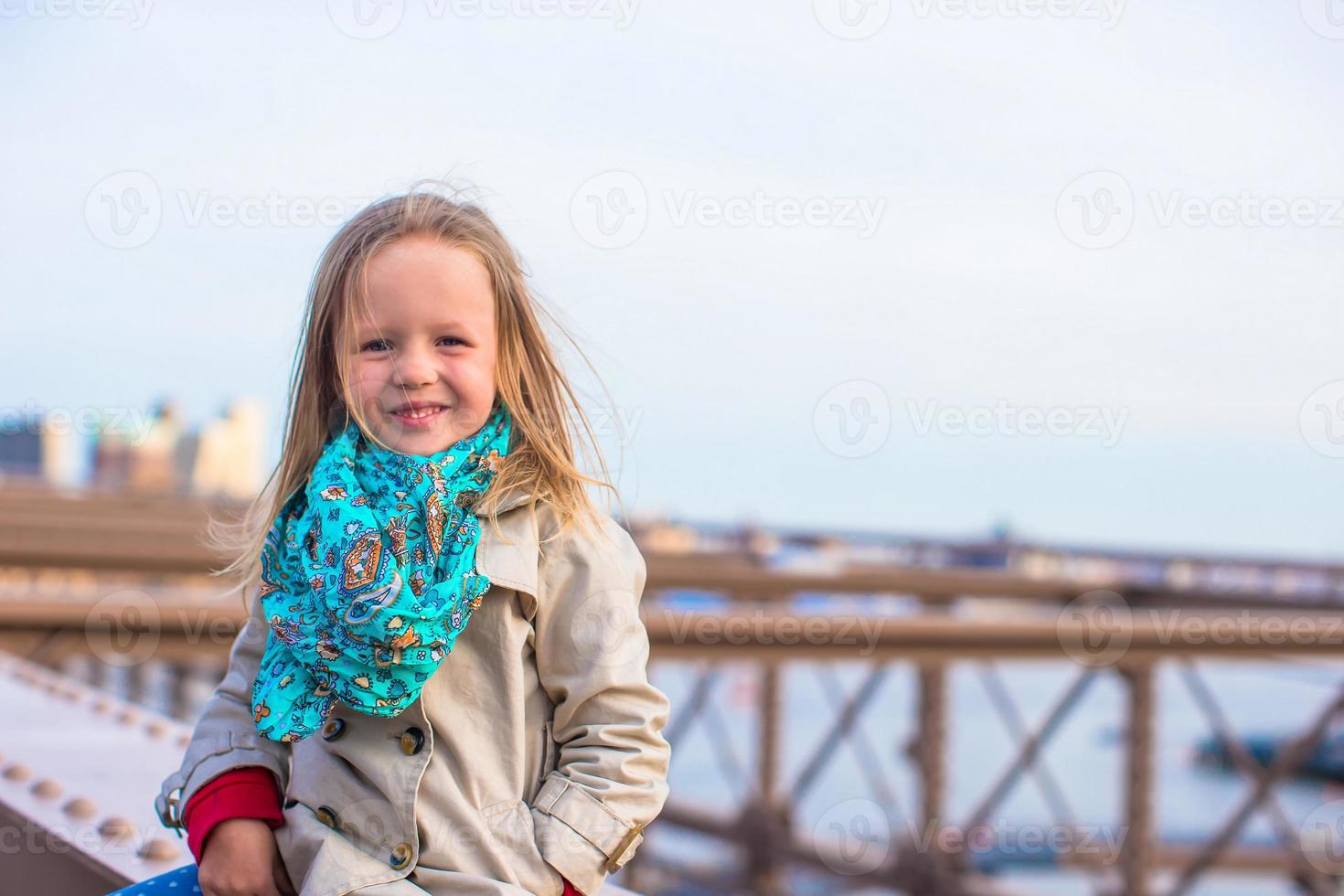 adorable petite fille assise au pont de brooklyn photo