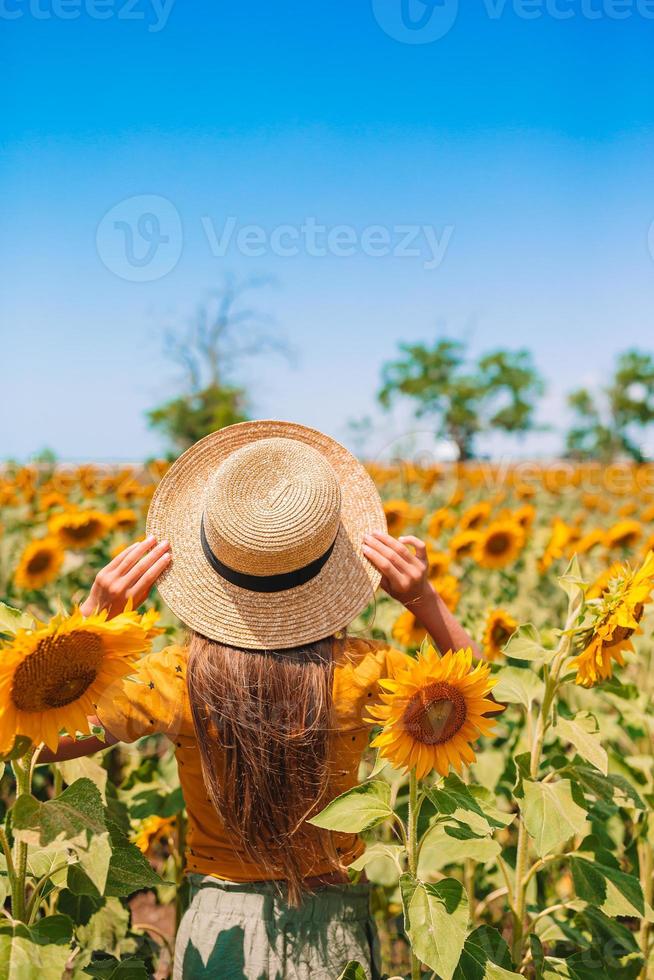 jeune fille profitant de la nature sur le champ de tournesols. photo