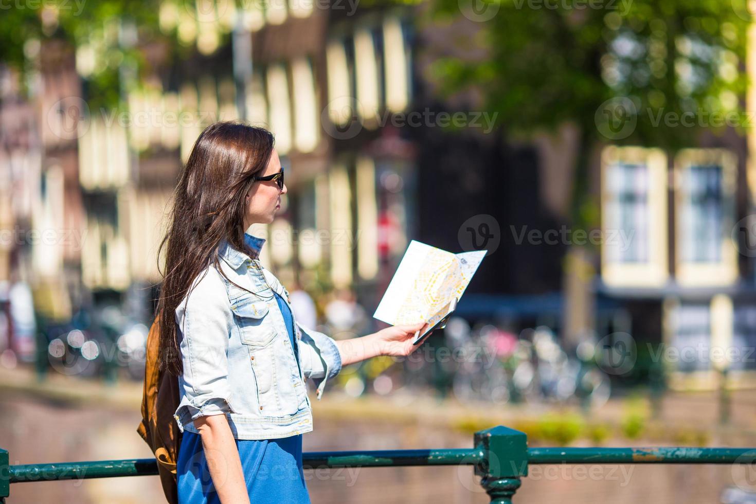 jeune femme heureuse avec un plan de ville et un sac à dos en europe photo
