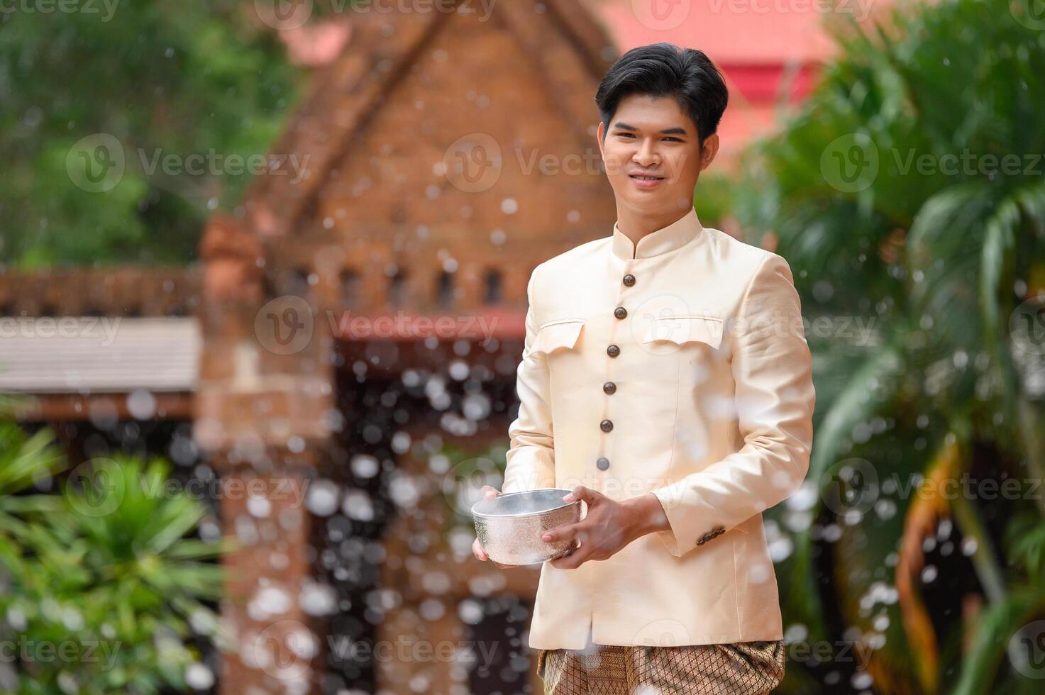 jeune homme éclaboussant de l'eau du bol sur le festival de songkran photo