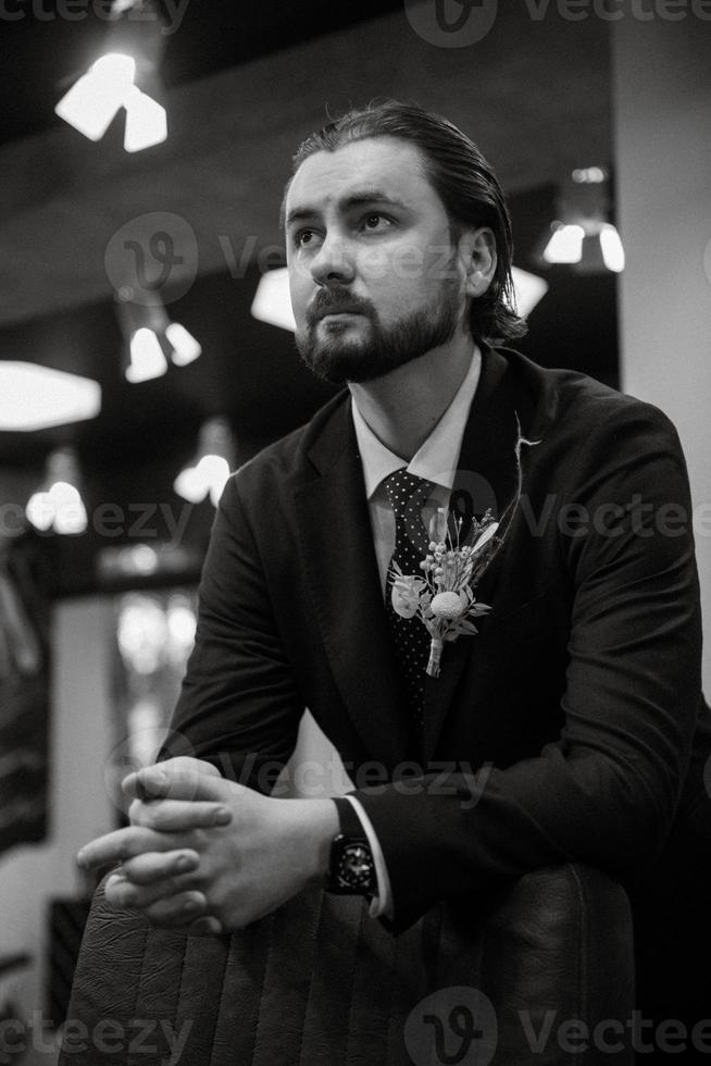 portrait d'un marié masculin dans un costume bleu dans le salon de coiffure du matin photo