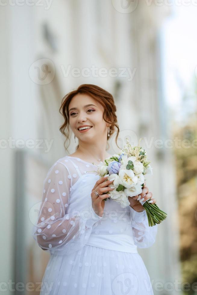 portrait d'une jeune mariée en robe légère en milieu urbain photo