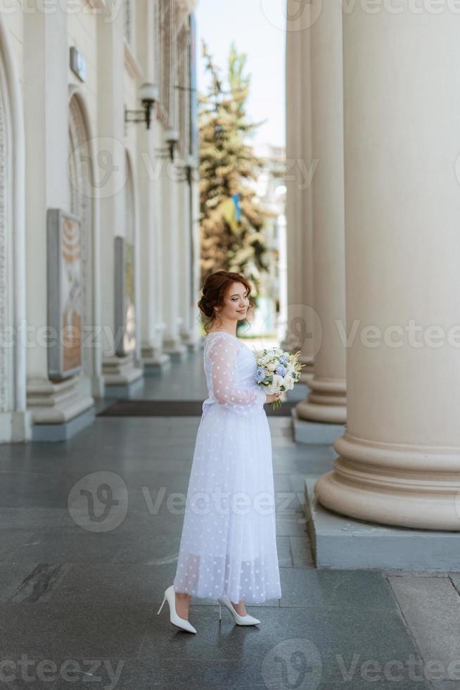 portrait d'une jeune mariée en robe légère en milieu urbain photo