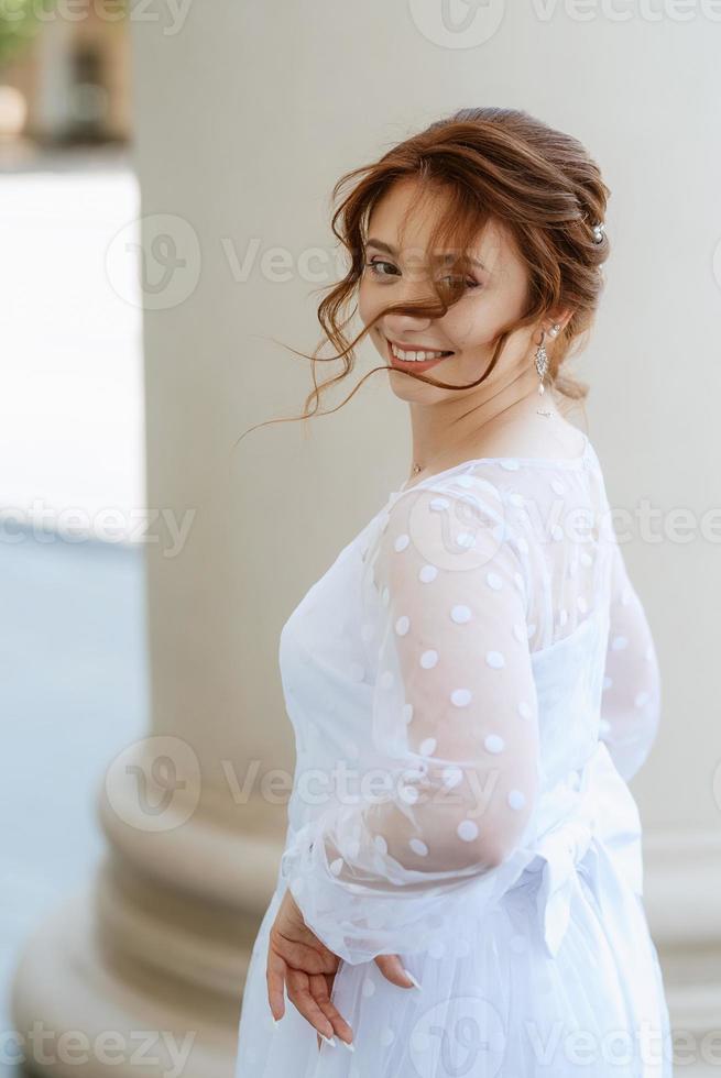 portrait d'une jeune mariée en robe légère en milieu urbain photo