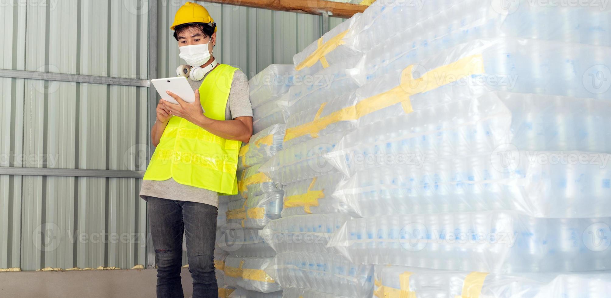 travailleur asiatique vérifiant le stock de bouteilles en plastique dans l'entrepôt et comparant le numéro d'équilibrage dans le système après l'expédition de la livraison. utiliser une tablette pour mettre à jour le stock en ligne photo