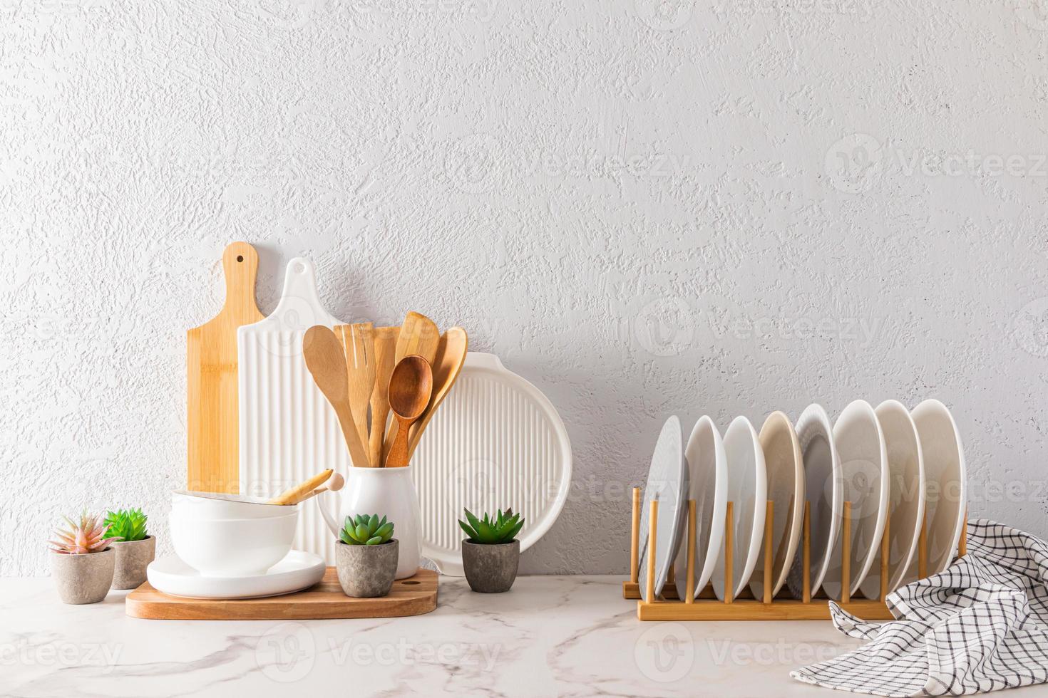 un ensemble d'ustensiles de cuisine et de plats aux couleurs claires sur un comptoir en marbre blanc sur fond de mur texturé gris. fond intérieur. photo