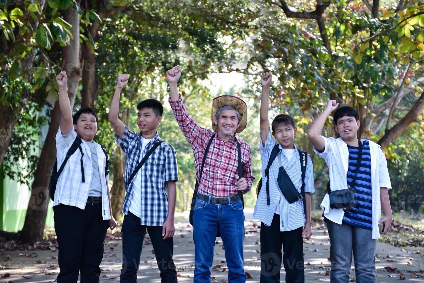 mise au point douce d'un professeur de musicien asiatique âgé debout avec ses élèves pendant la leçon de musique en plein air, mise au point douce et sélective, un adulte aide les élèves à propos du concept de travail de projet scolaire. photo