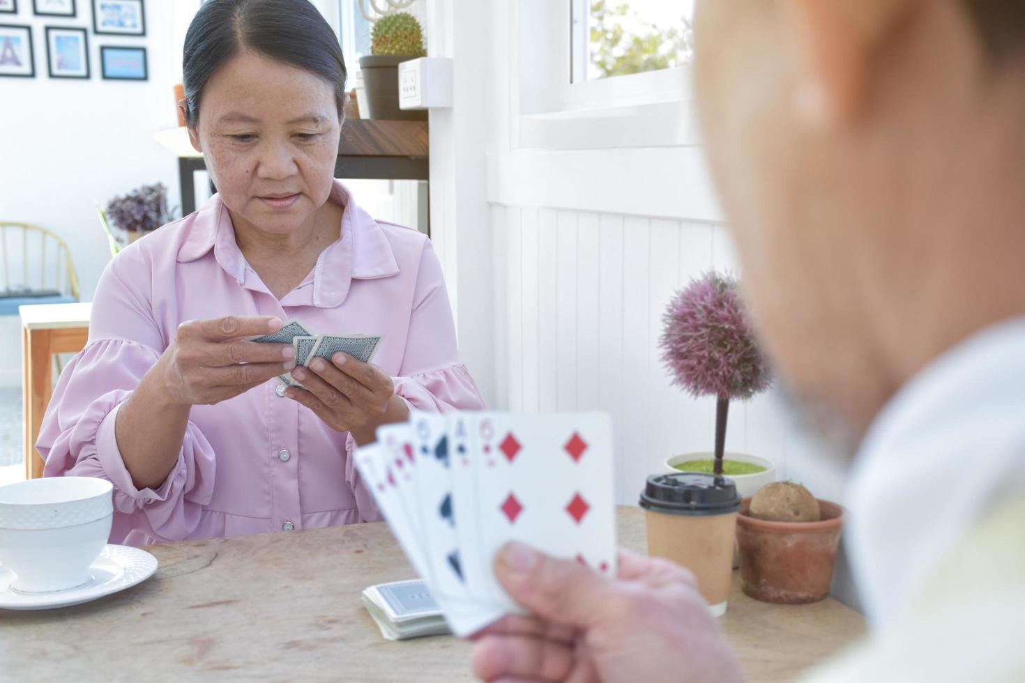 jeu de cartes des personnes âgées à la maison pendant leurs temps libres, les loisirs et le concept de bonheur des personnes âgées. photo