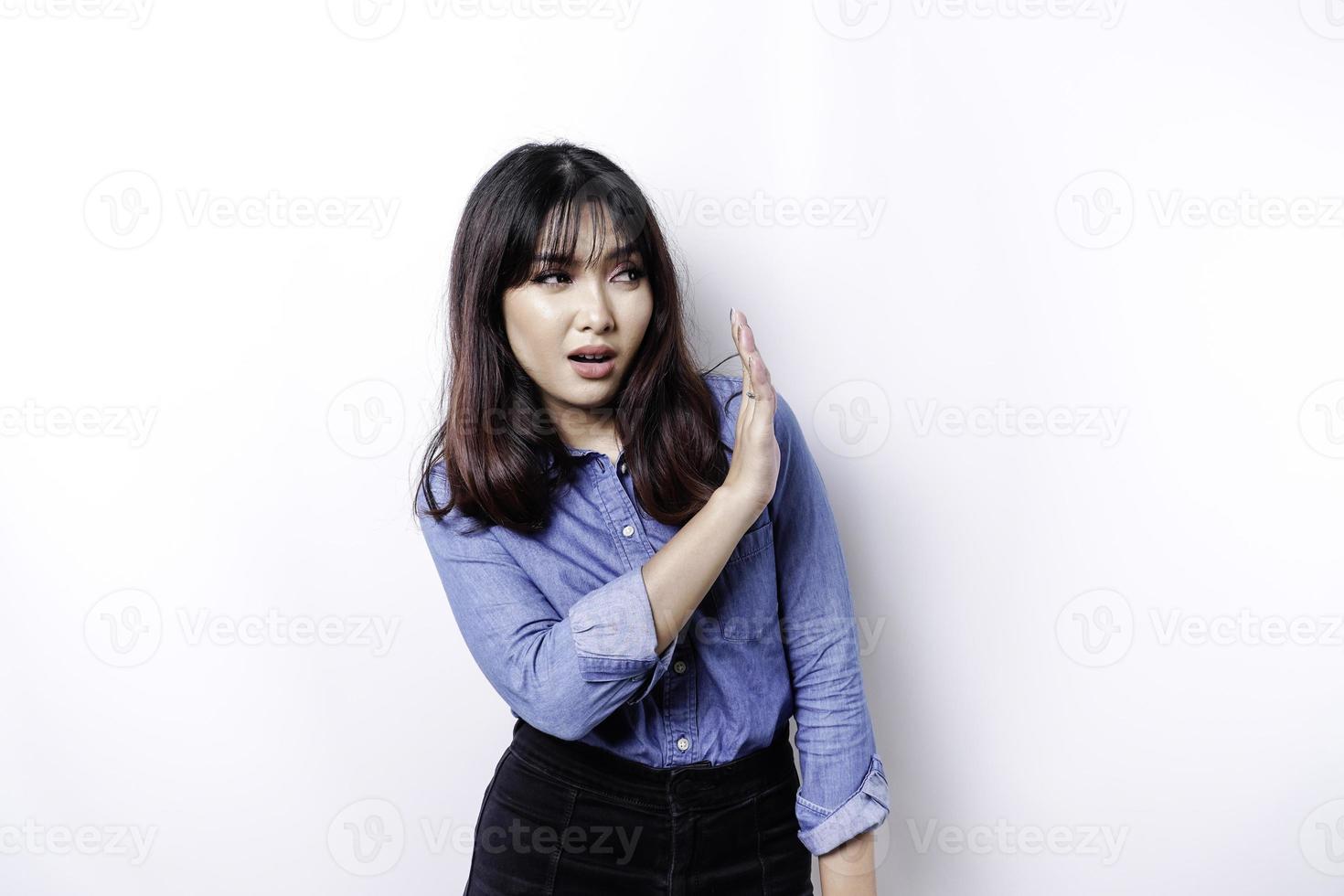 jeune femme asiatique isolée sur fond blanc, a l'air déprimée, le visage couvert de doigts effrayés et nerveux. photo