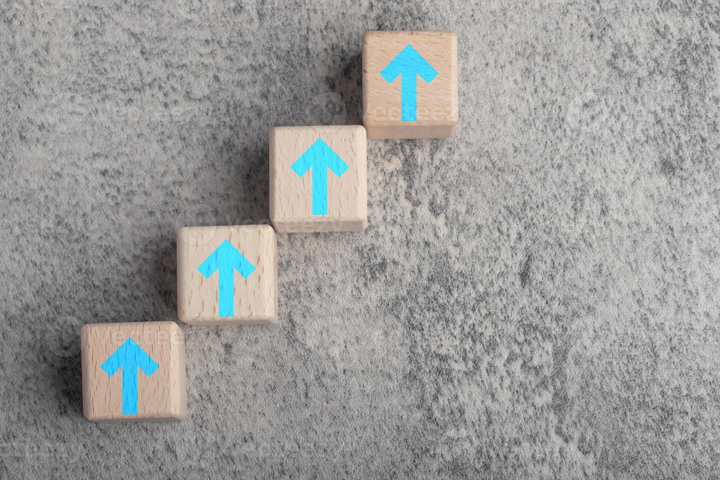 blocs de bois disposés en escaliers. concept ligne courbe de flèche montante monter l'escalier pour cibler comme métaphore de la croissance commerciale et financière, succès à l'avenir photo