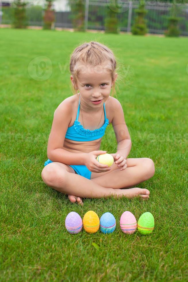 petite fille avec des oeufs de pâques sur l'herbe dans sa cour photo